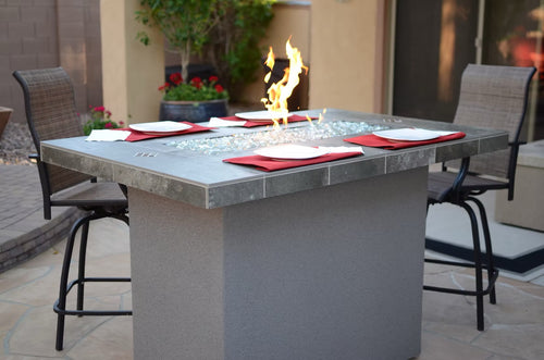 Gas fire pit table with glass surround. Entertainer-style design. Weather-resistant, functional bar. Premium outdoor entertaining.