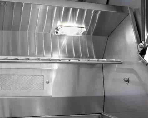 Wildfire Ranch PRO 36-inch grill interior with built-in cooking light illuminating the stainless steel firebox and warming rack.
