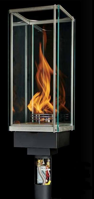 Glass-enclosed outdoor fire torch with flames on a black background