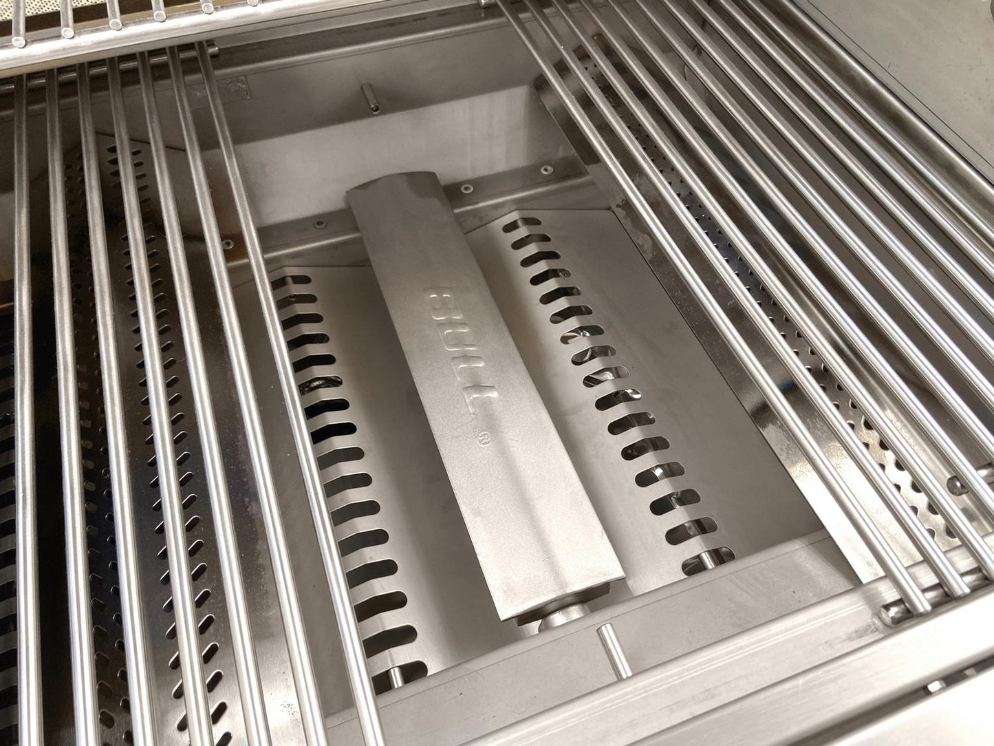 Close-up of Bull Angus grill interior showing stainless steel cooking grates, flame tamers and burner system.