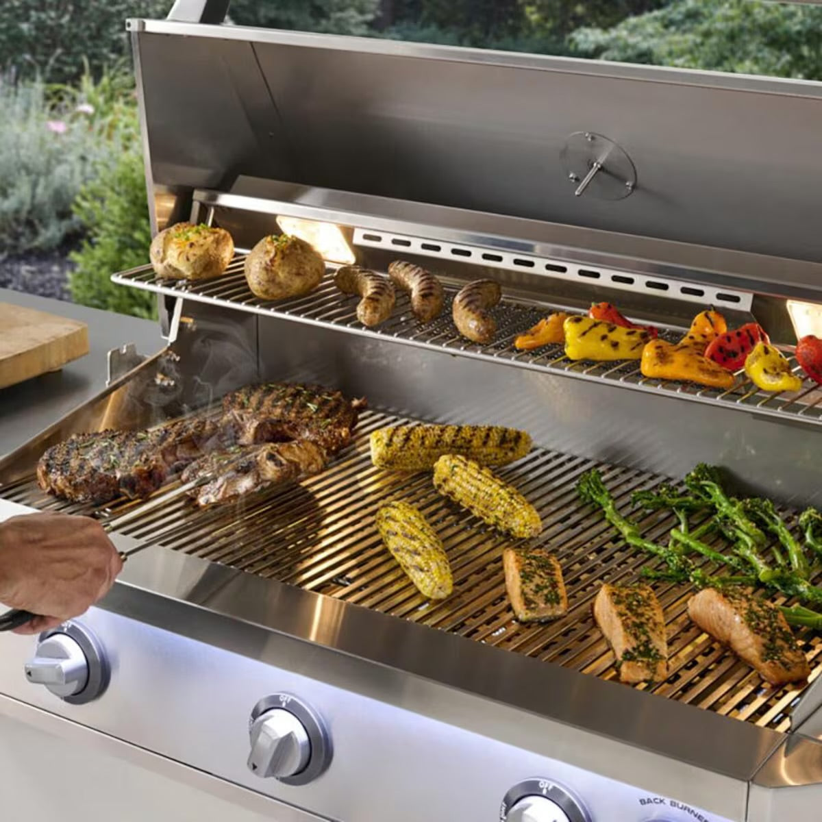 American Outdoor Grill 30-in L-Series built-in gas grill grilling steak, salmon, corn, and broccolini outdoors