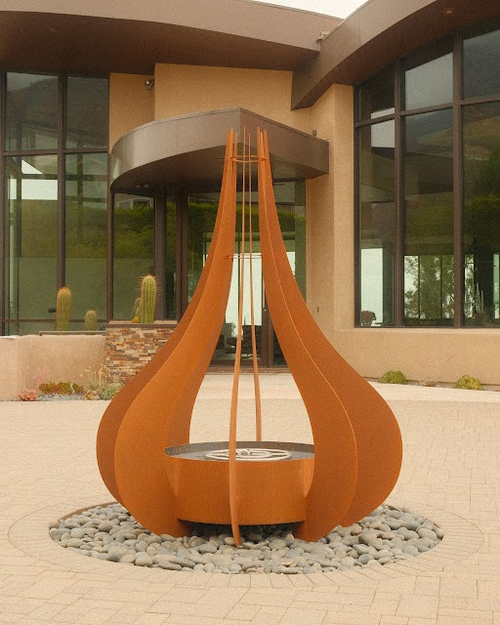 The Comet metal powder coat fire sculpture with active flames, modern outdoor art piece for luxury landscape and entertaining spaces