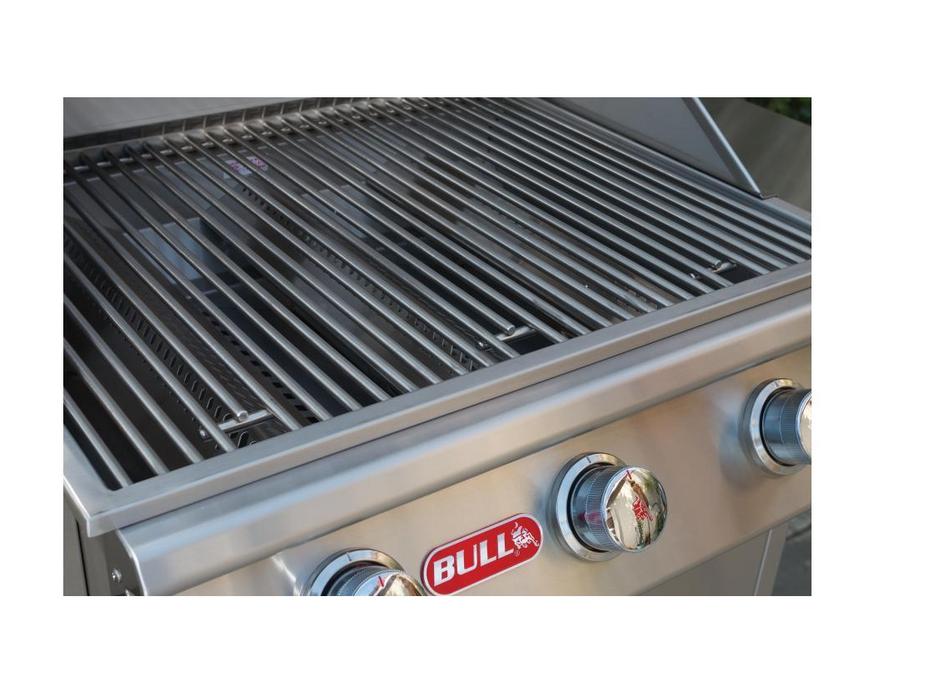Close-up of BULL Steer 24-inch gas grill showing stainless steel cooking grates, three control knobs and BULL logo.