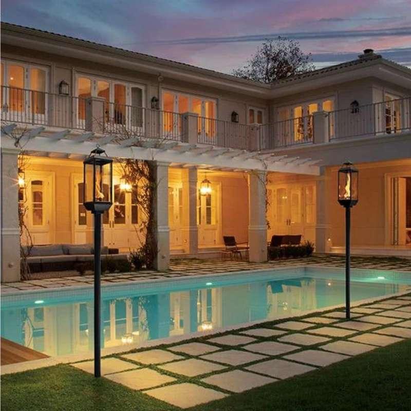 Tempest outdoor gas lanterns illuminating luxury swimming pool at night